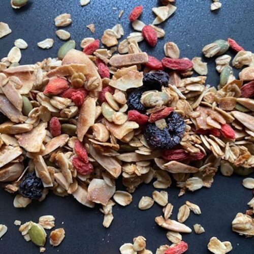 granola close up, scattered on a matte black surface