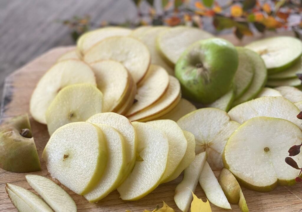 apples sliced across the core, laid out on cutting board.