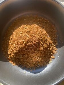 pile of homemade chili powder in a bowl, from above, with sun shining