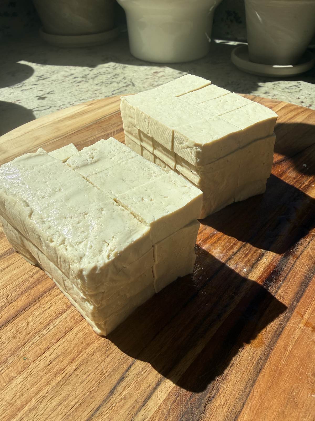 block of tofu shown with multiple knife cuts creating 1/2" cubes of tofu.