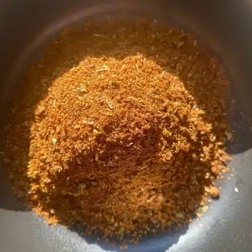 pile of homemade chili powder in a bowl, from above, with sun shining