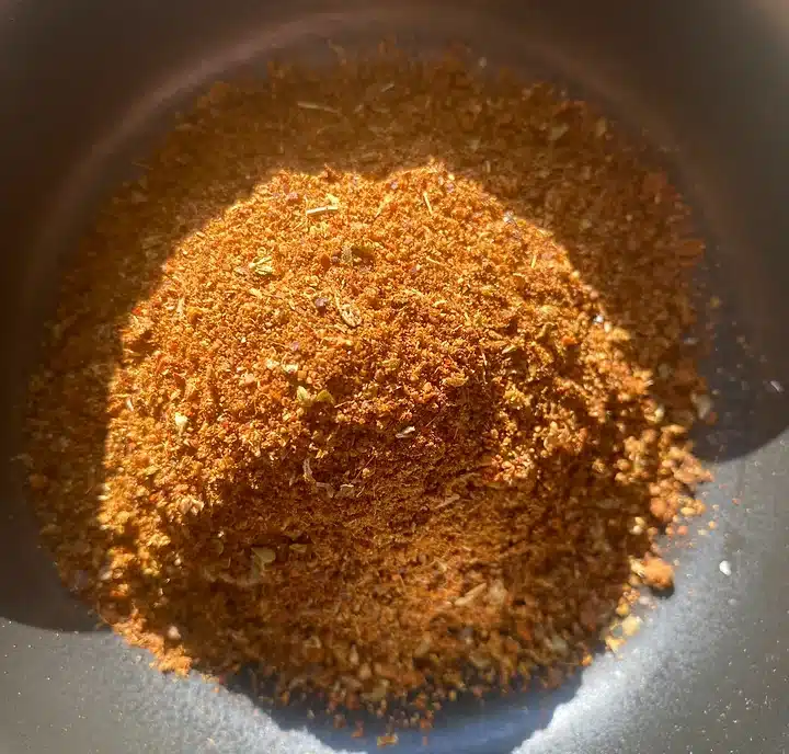 pile of homemade chili powder in a bowl, from above, with sun shining