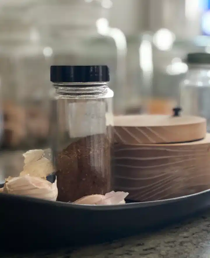 bottle of homemade chili powder on counter with other kitchen items