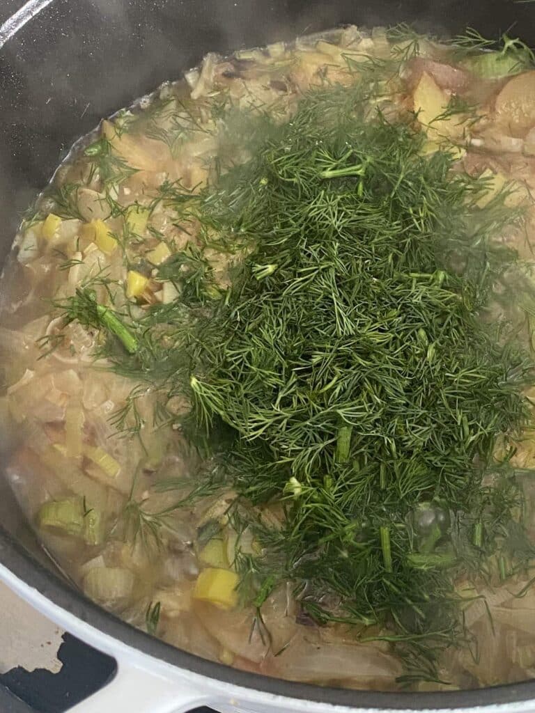 lots of fresh dill added to pot of leek and potato stew.