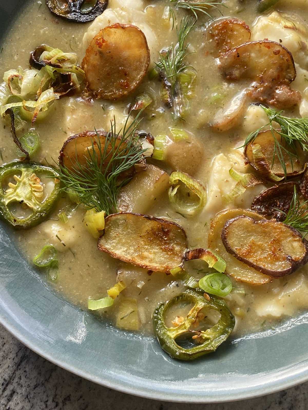 close up of fish and potato stew with all the toppings.