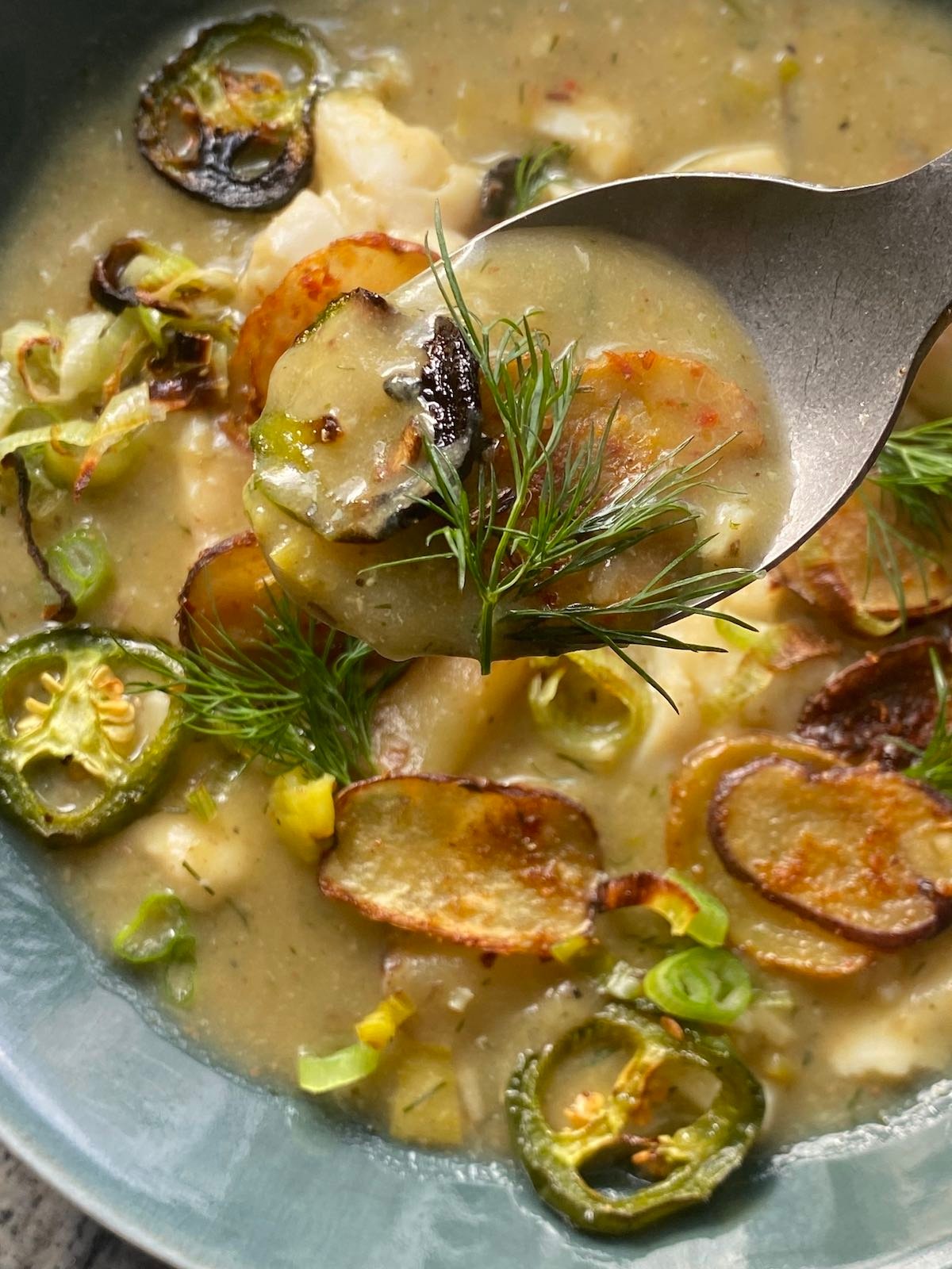 crispy potato and fish stew with some on a spoon.