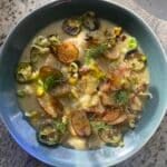 bowl of thick fish and potato stew with crispy potato and fresh dill garnish.