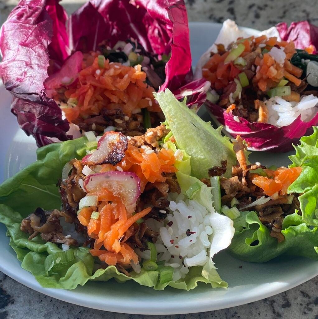 plate of three shredded tofu and mushroom lettuce wraps.