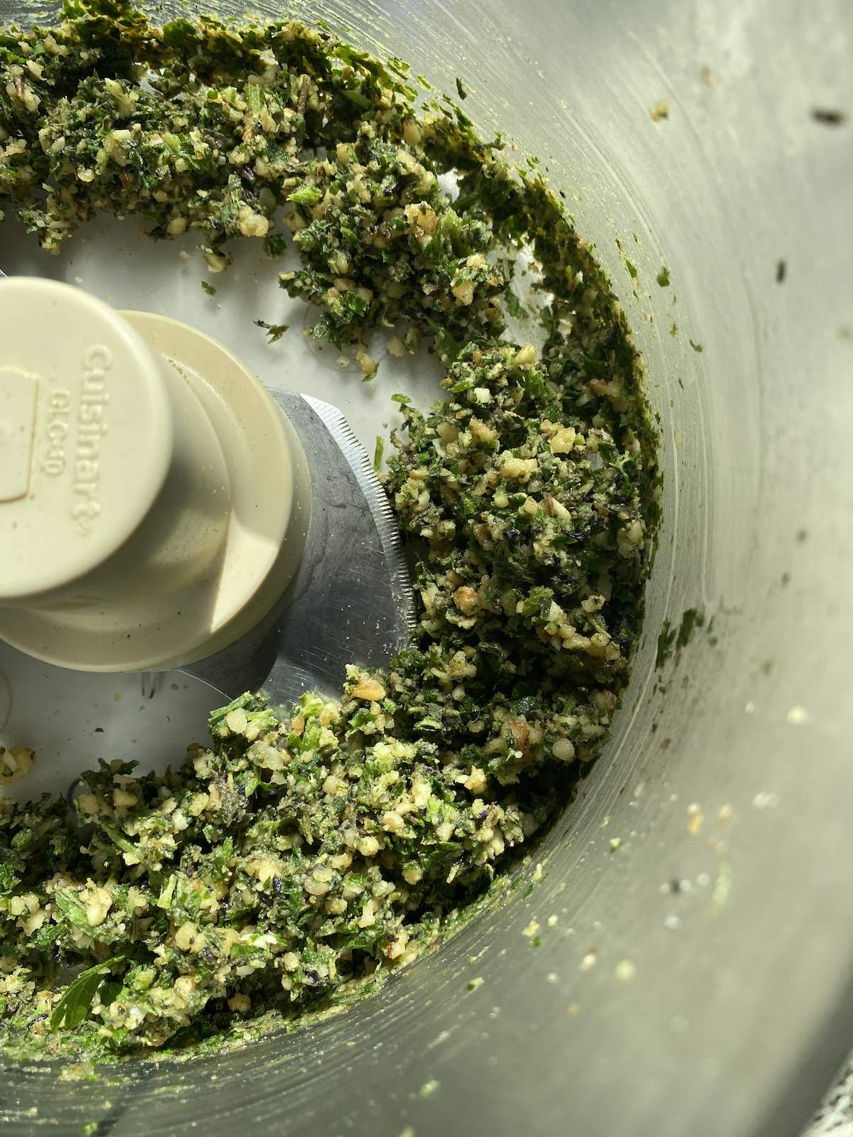 the ingredients for miso herb pesto in food processor, partially blended, but still of a coarse consistency.
