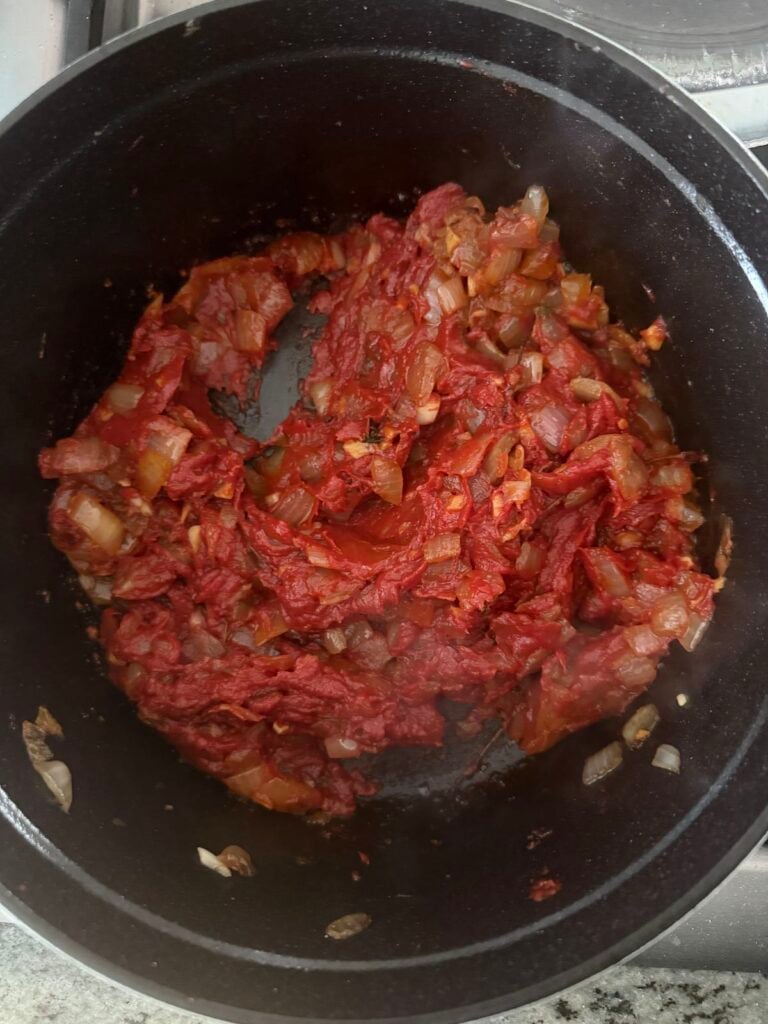 tomato paste added to sauteed onions and garlic, and sauteeing to caramelize for flavor.