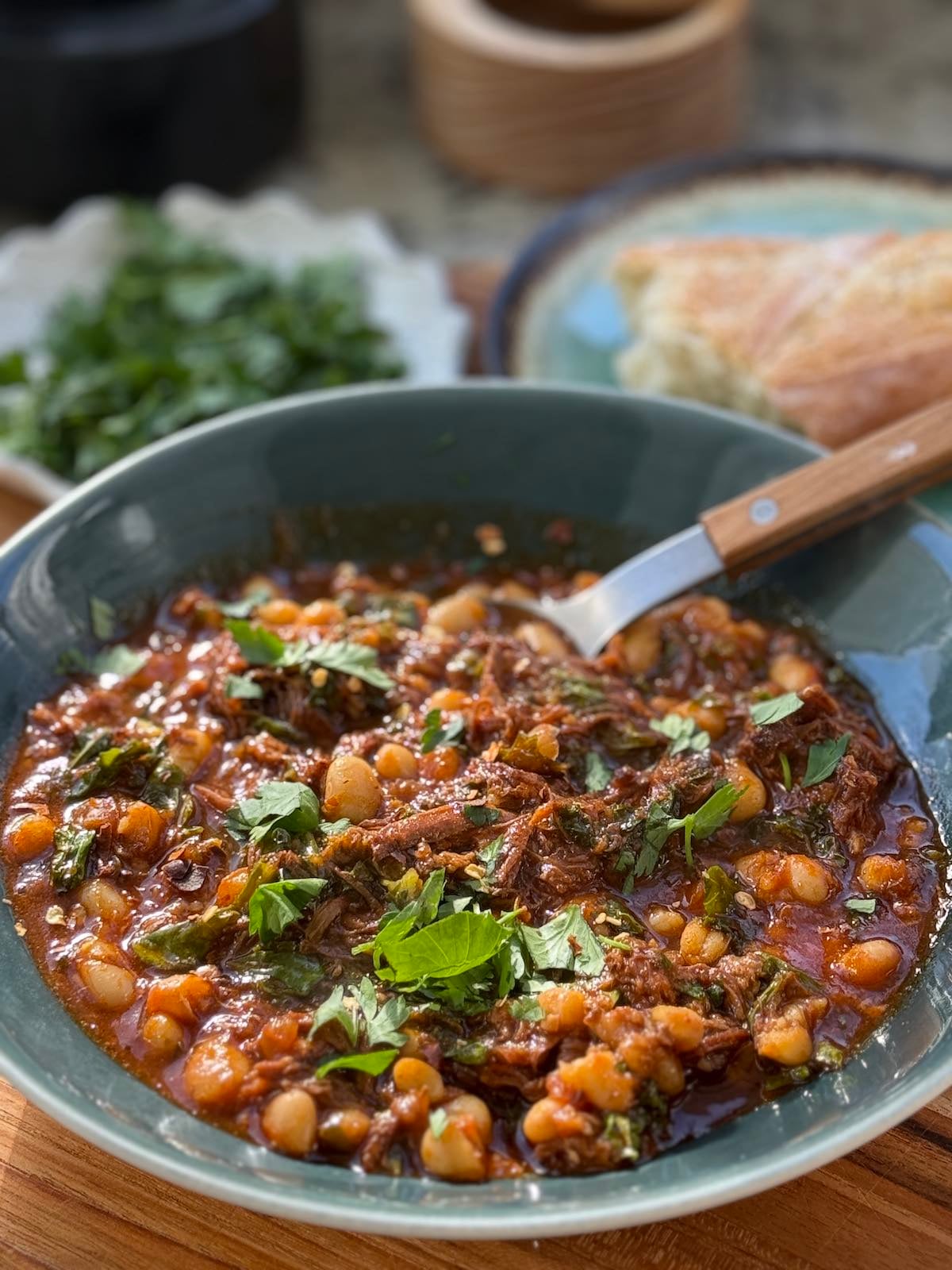 Serving of beef ragu with greens and beans.