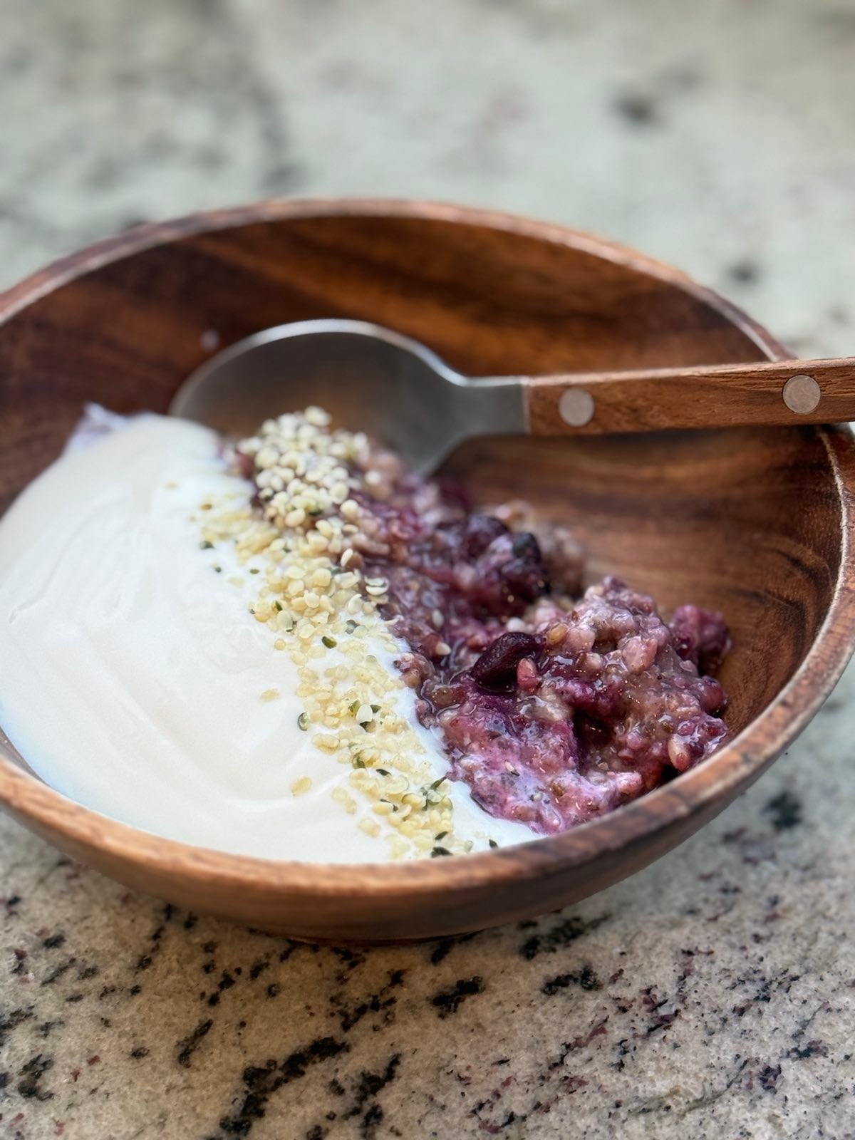 steel cut oats mixed and reheated with fruit compote and served with yogurt and hemp seeds.
