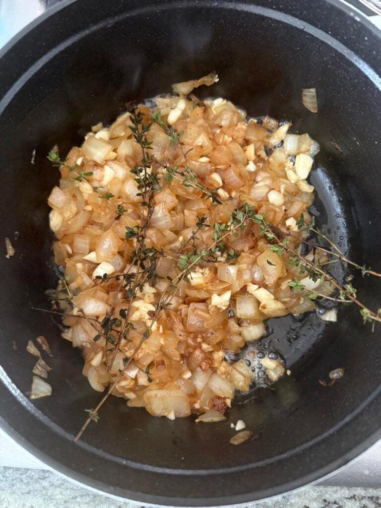 onions, garlic and fresh thyme sauteeing in pan.