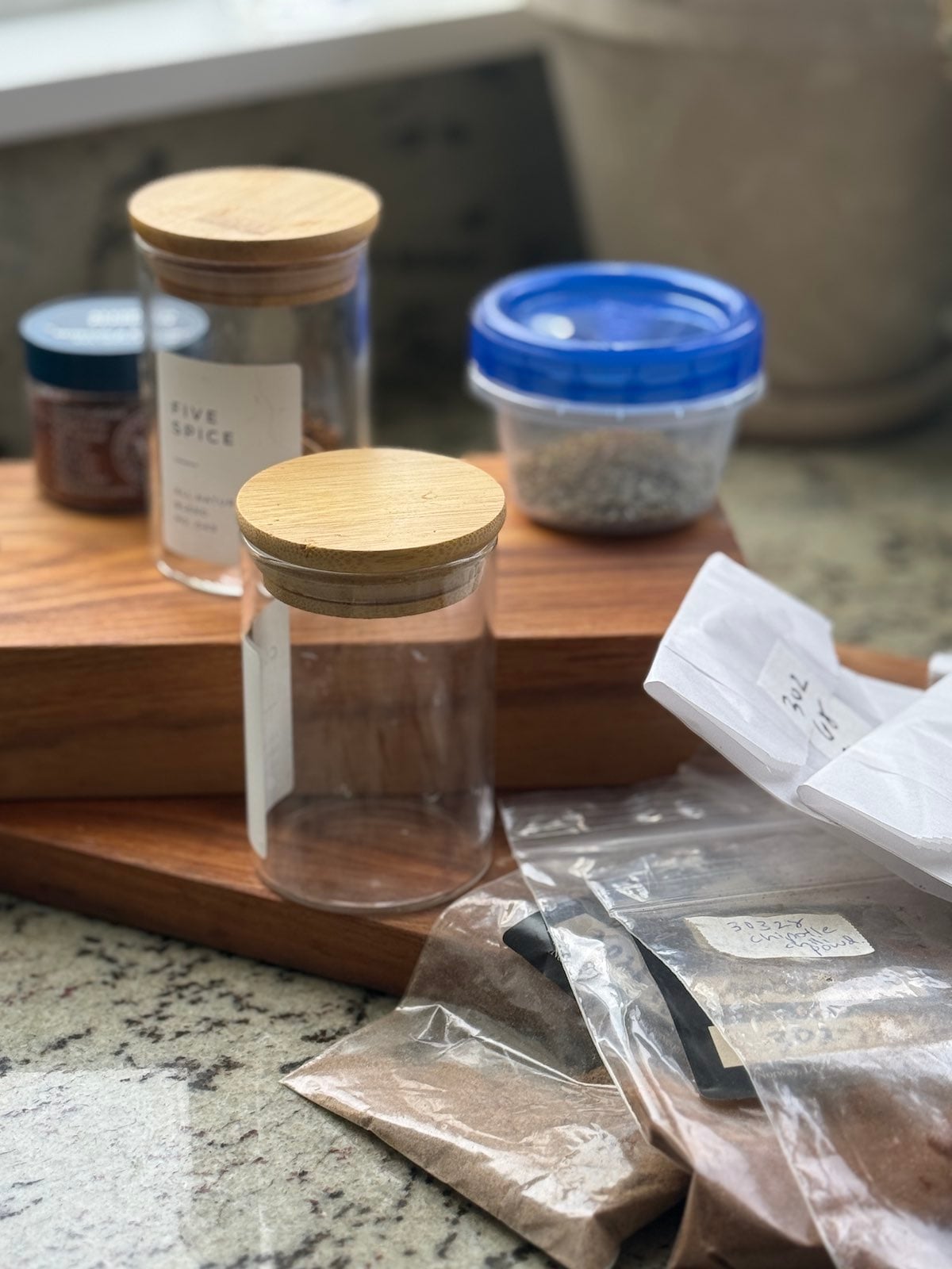 individual bags of spices and different types of small containers to use for storing the spices.