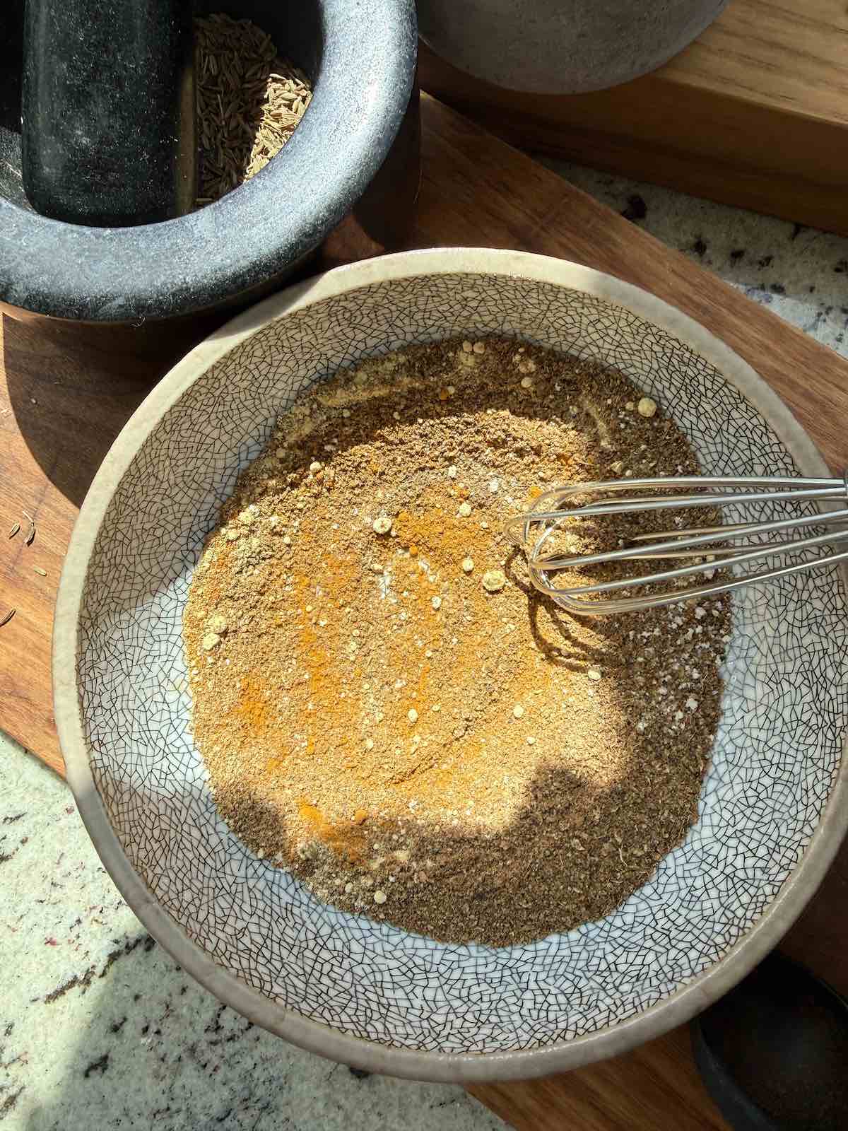 mixing various curry spices together for a marinade and curry sauce.
