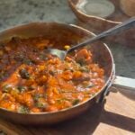 large saute pan with finished turkey curry with spinach and butter beans.