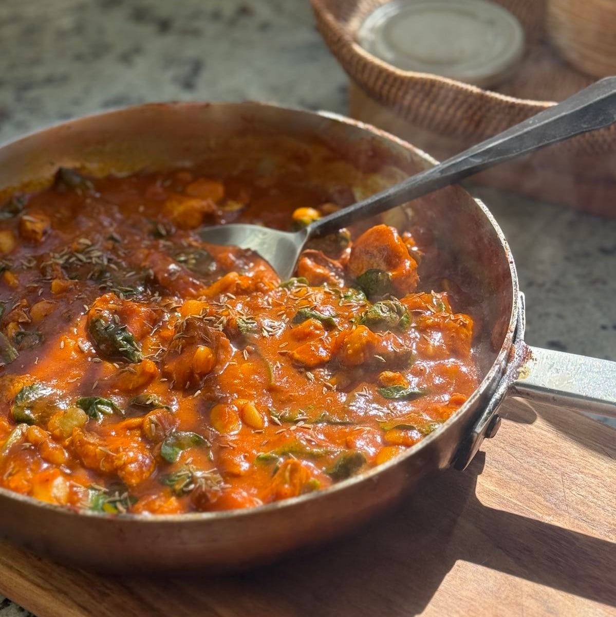 large saute pan with finished turkey curry with spinach and butter beans.