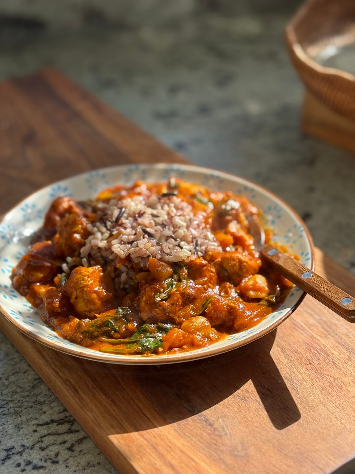 serving of turkey curry on a plate with wild rice and a fork.