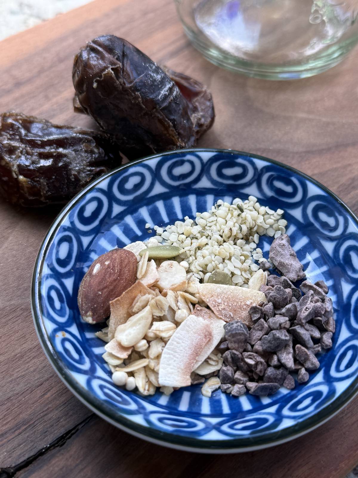 a little dish with hemp seeds, granola, and cacao nibs to be used as smoothie toppings.